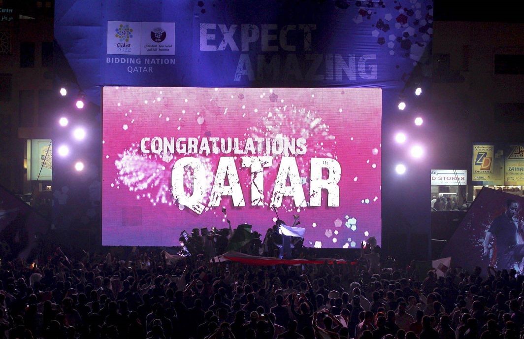 People celebrate in front of a screen that reads “Congratulations Qatar” after FIFA announced that Qatar will be host of the 2022 World Cup in Souq Waqif in Doha (file photo). Photo: UNI