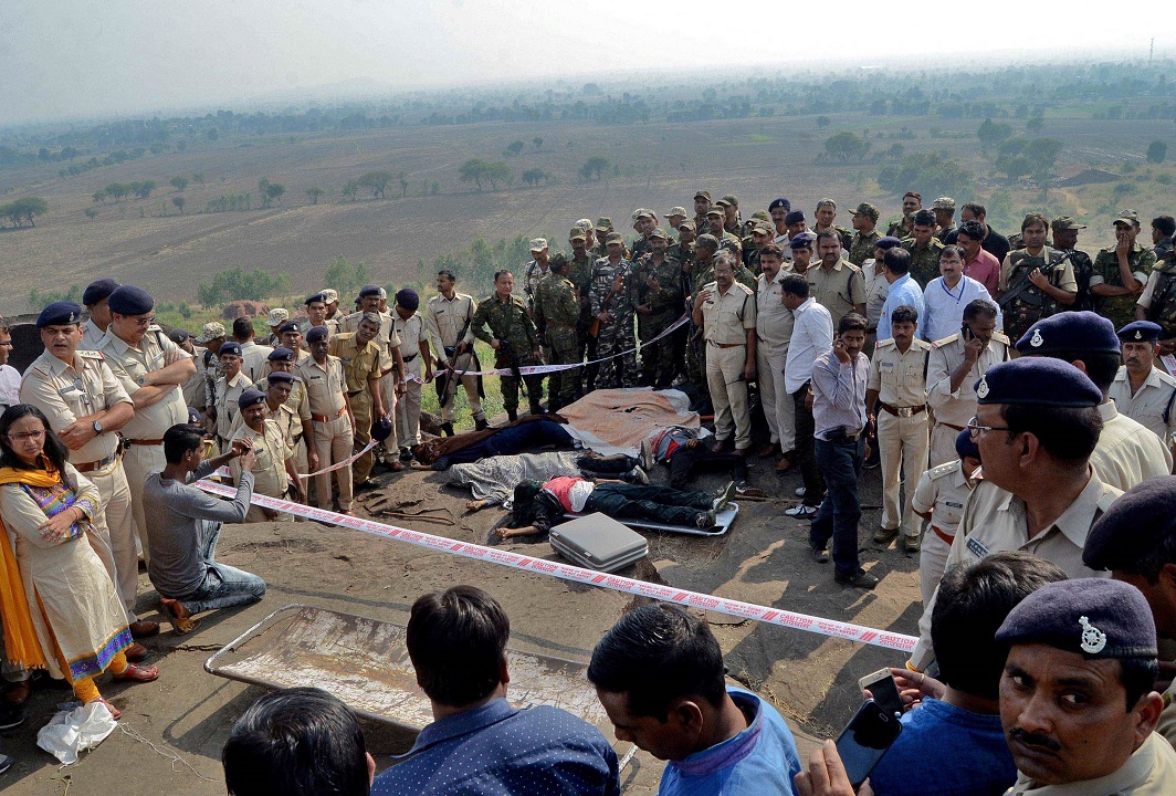 Police officers and Special Task Force soldiers stand beside dead bodies of the suspected members of the banned Students Islamic Movement of India (SIMI), who escaped the high security jail in Bhopal, and later got killed in an encounter on the outskirts of Bhopal, India. Photo: UNI