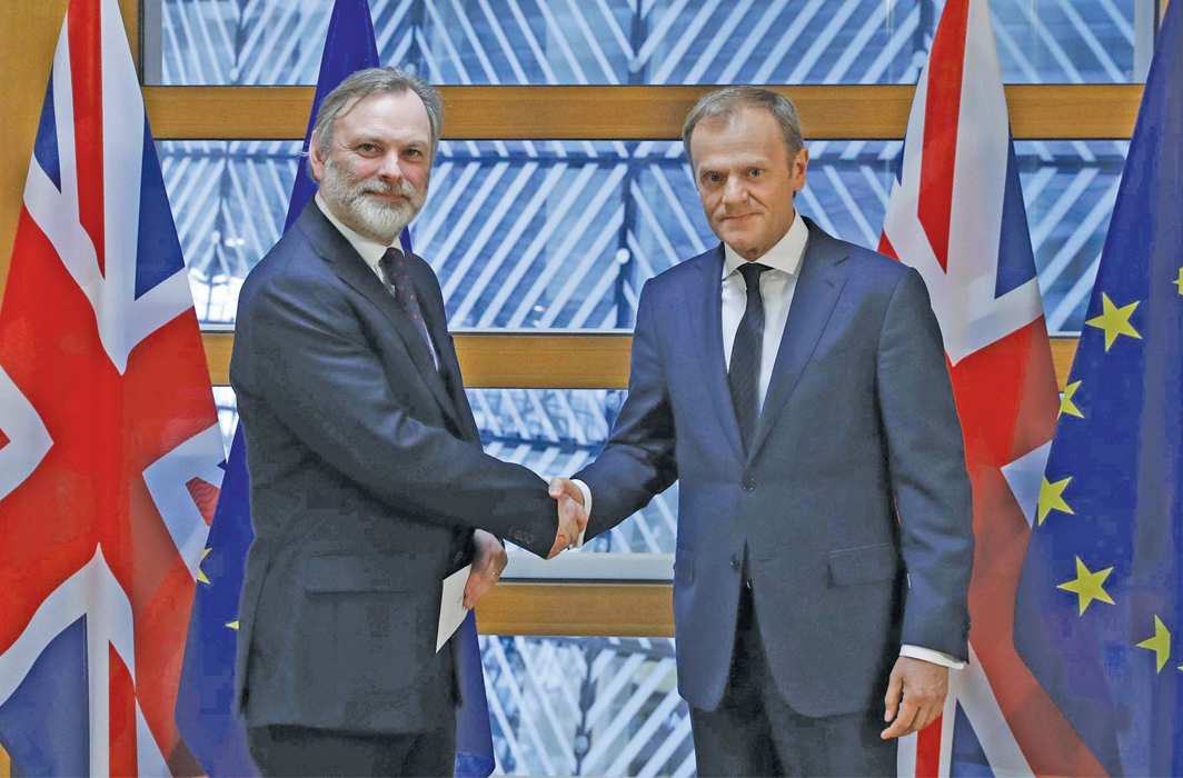 Britain s envoy to the European Union Tim Barrow left delivers