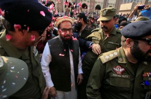 Hafiz Saeed is showered with flower petals as he walks to court before his release order. Photo: UNI