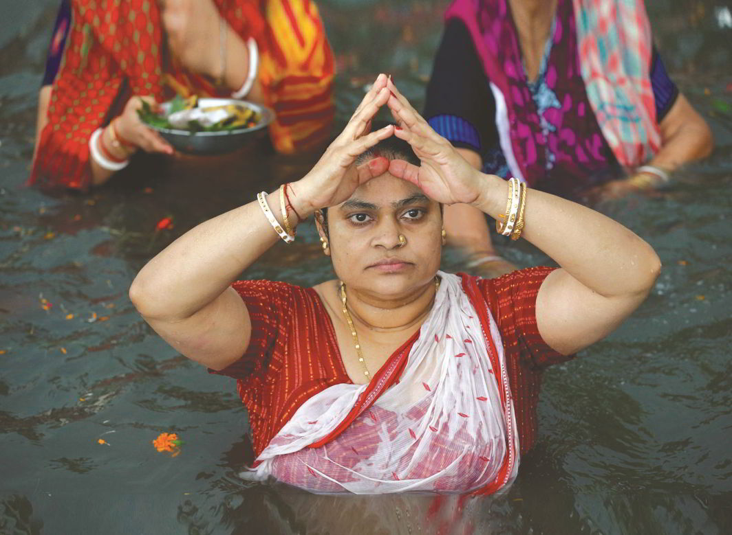 A Hindu woman takes a Mahashtami dip in the Brahmaputra. Bangladeshi Hindus share roots and customs with their Indian counterparts. Photo: UNI