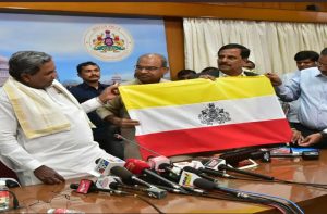 Siddaramaiah along with other officials unveiling the karnataka state flag