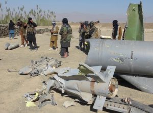 Taliban militants stand next to the wreckage of a damaged aircraft, in Sayed Karam district, Afghanistan/Photo: UNI