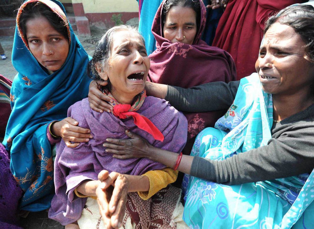 A victim of the Muzaffarnagar riots breaks down while others console her/Photo: UNI