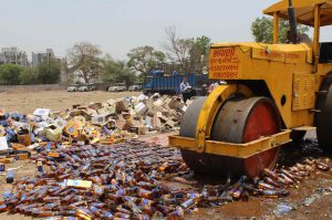 Police officials destroy seized illegal liquor stock in Ahmedabad/Photo: UNI