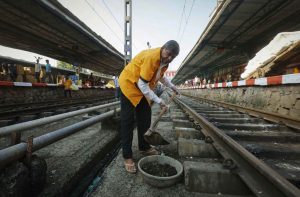 A worker cleans a railway track at a station in Mumbai. Many overqualified people apply for such menial jobs in government/Photo: UNI