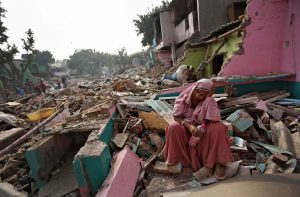 A slum-dweller rests amid the rubble of her home, demolished by the authorities in Delhi/Photo: UNI