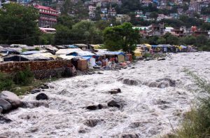 Flood water of Sarvari river may prove disastrous to migrant workers in Kullu district, who are living in sheds alongside the banks of Sarvari river/Photo: UNI