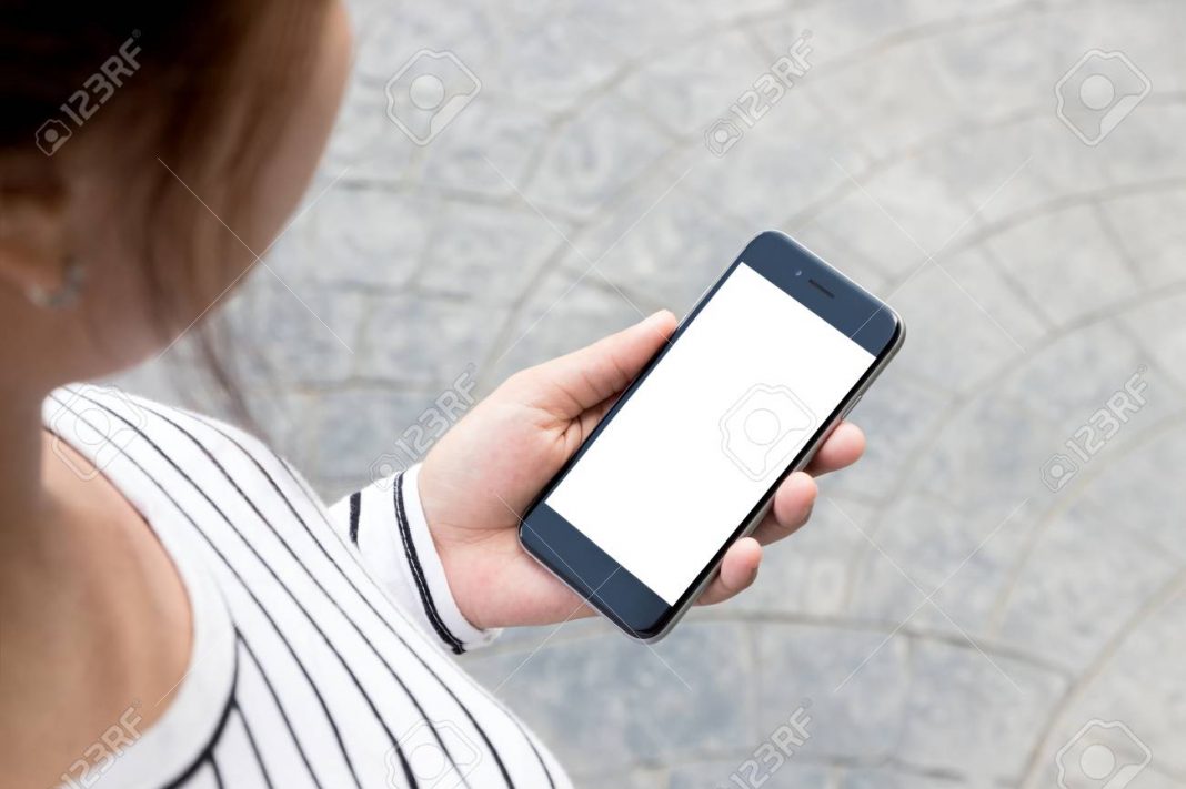 woman-looking-phone-on-road-in-the-city-third-person