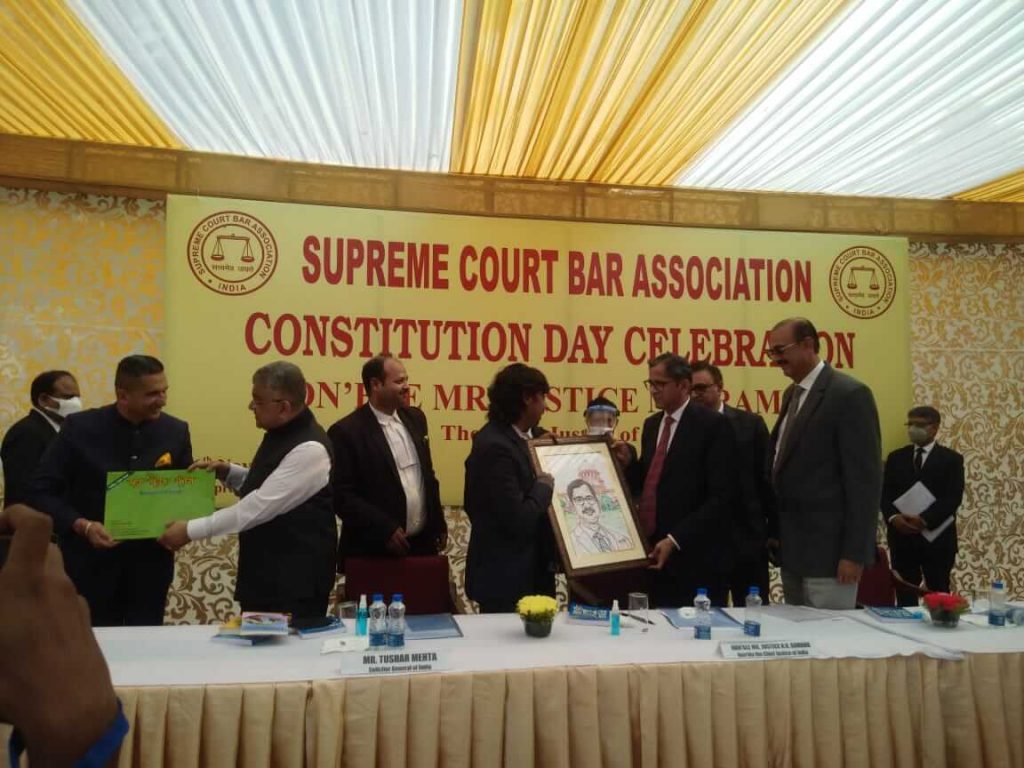 Apurv Om presents a sketch of the Chief Justice to Justice NV Ramana at the SCBA event to observe Constitution Day.   