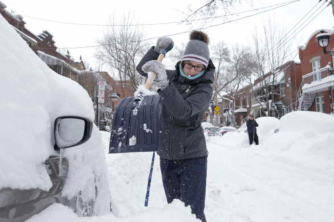 ICE, ICE BABY: A woman shovels snow away from her car after a storm in Quebec, Reuters/UNI