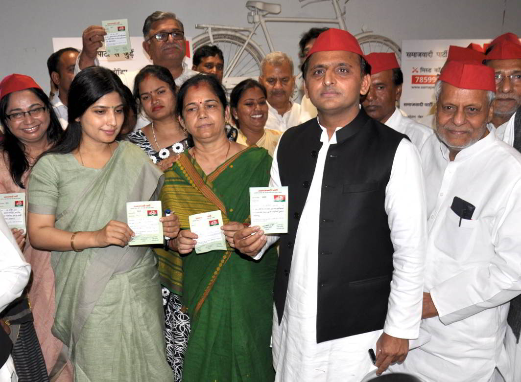 PICKING UP THE PIECES: Samajwadi Party president Akhilesh Yadav, with wife and party MP Dimple Yadav, distributes party membership slips at the SP office in Lucknow, UNI