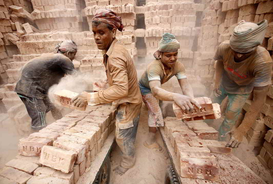 Brick factory workers load carts with bricks to take them into warehouse in Dhaka, Reuters/UNI