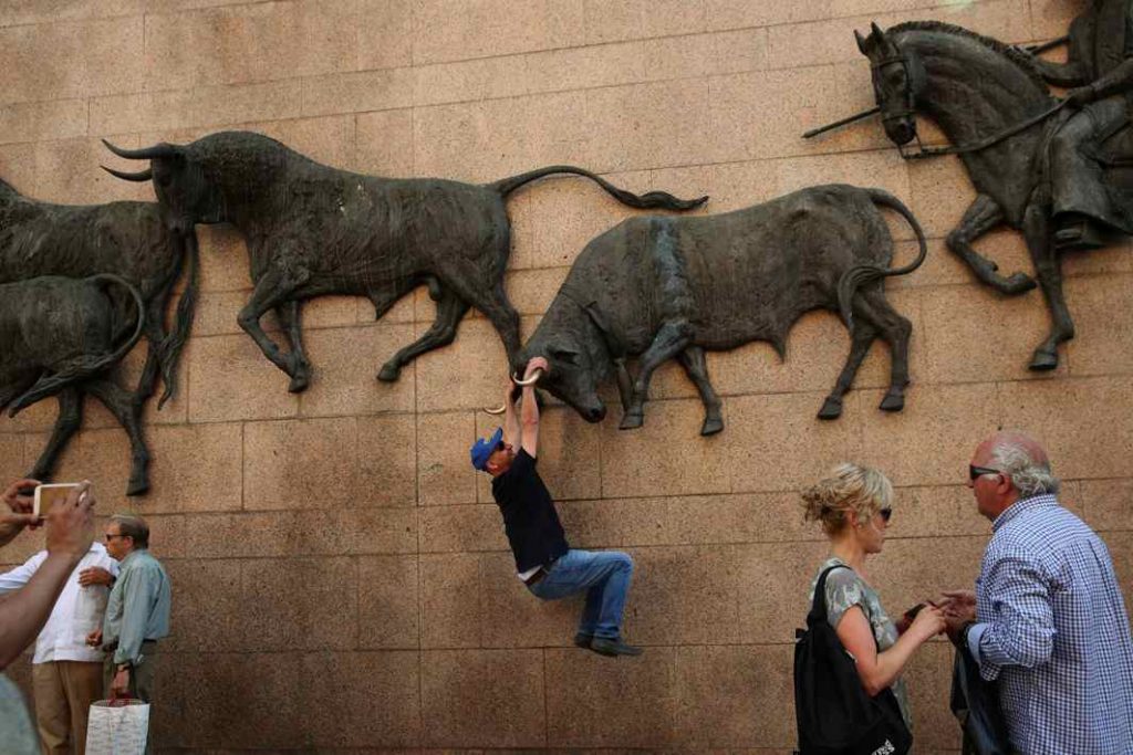 SHADOWFIGHTING: A man has his photo taken hanging from a bull sculpture outside Las Ventas bullring during San Isidro's bullfighting fair in Madrid, Reuters/UNI