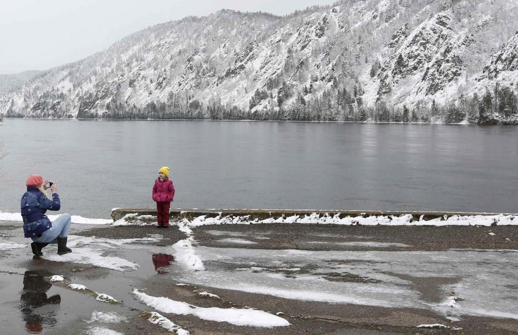 IN THE WILDERNESS: A woman takes pictures of a child on the embankment of the Yenisei river after a heavy snowfall in the Siberian town of Divnogorsk in Krasnoyarsk region, Russia, Reuters/UNI