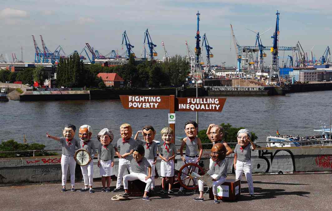IN YOUR HANDS: Activists from OXFAM wear masks depicting some of the world leaders during a demonstration at the harbour in Hamburg during the G20 summit, Germany, Reuters/UNI