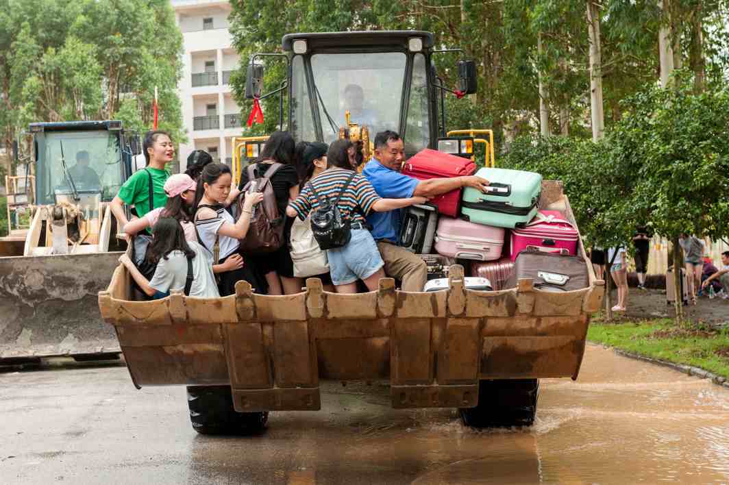 WATERY RECESS: Students are transferred by a forklift through a flooded area at a college in Guilin, Guangxi province, China, Reuters/UNI