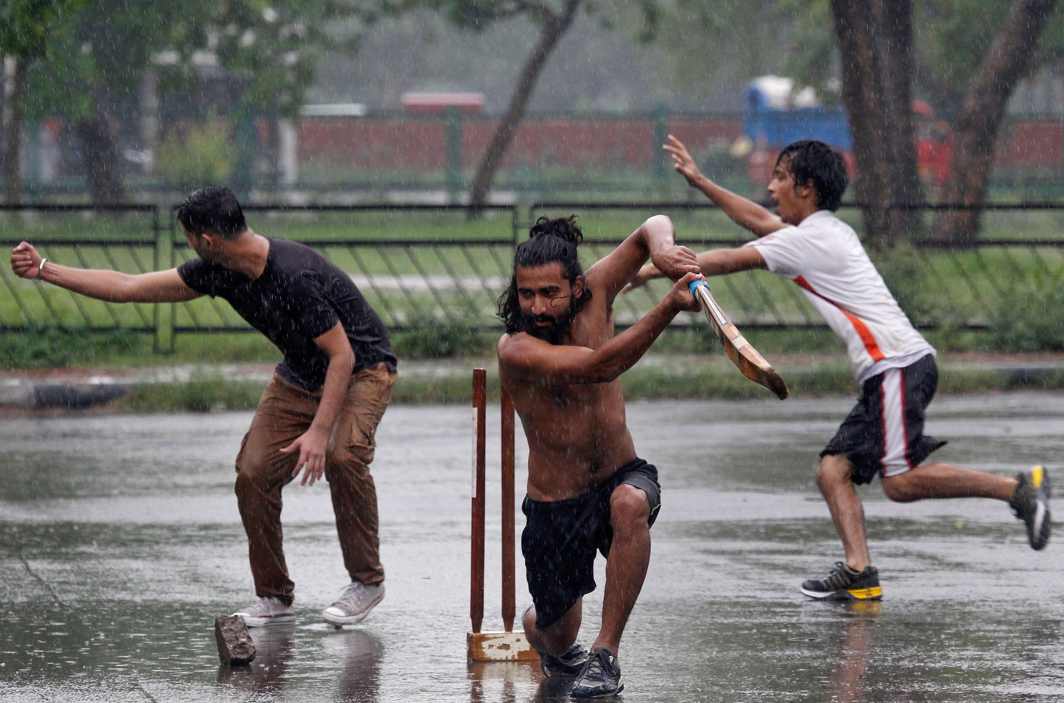 HOW BEAUTIFUL IS THE RAIN: Boys play cricket at a parking lot as it rains in Chandigarh, Reuters/UNI