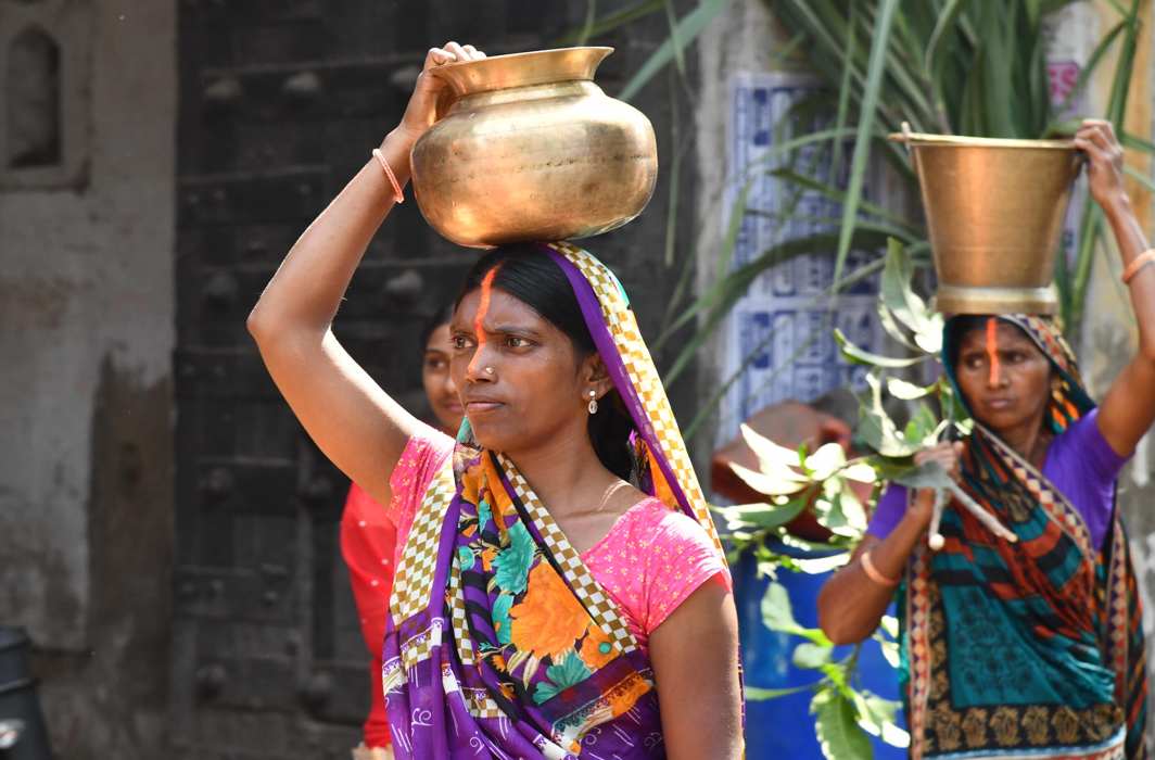 WALK OF FAITH: Women devotees carry pots filled with holy water of Falgu river for preparing prasad on the occasion of Chhatth Puja festival in Bodhgaya, UNI