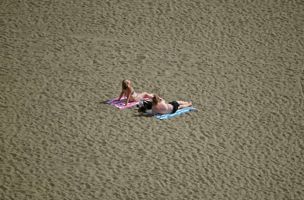 SUN AND SAND: People enjoy the beach on a warm fall day during a long weekend at the Malagueta beach in Malaga, Spain, Reuters/UNI