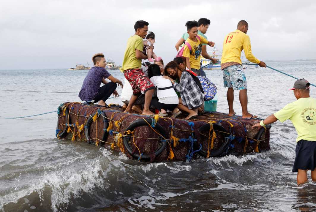 INCONVENIENCED: Stranded passengers ride on a makeshift raft after all ferry service was cancelled, a day after a Philippine vessel capsized because of bad weather in Infanta, Quezon in the Philippines, Reuters/UNI