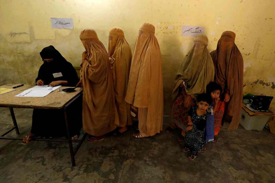 Women, clad in burqas, stand in line to cast their ballot at a polling station during general elections in Peshawar, Pakistan, Reuters/UNI