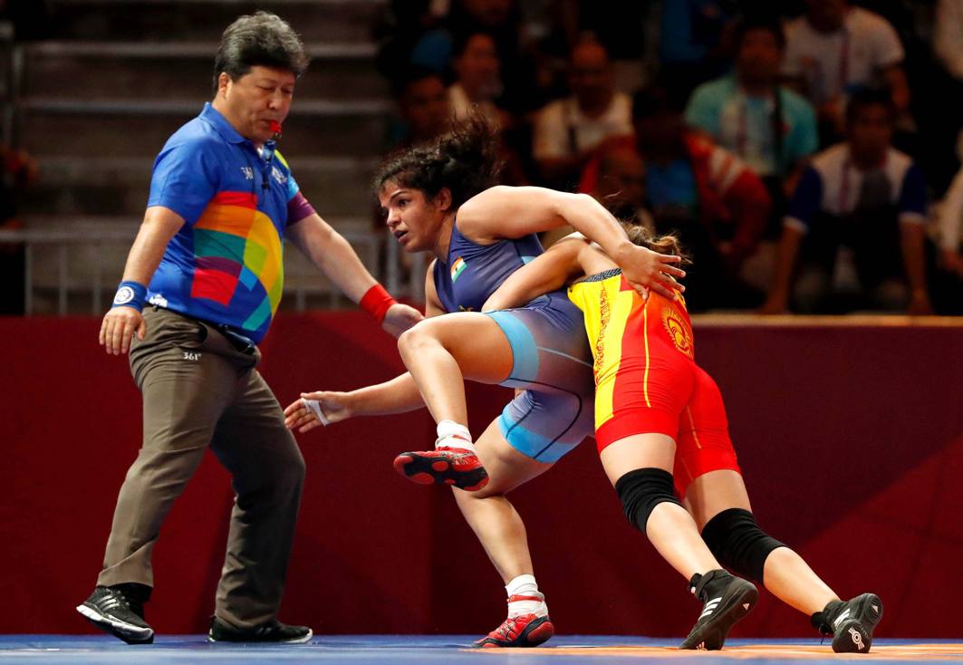 Aisuluu Tynybekova of Kyrgyzstan in action with Sakshi Malik of India at the Women's Freestyle 62 kg Semifinal in Jakarta, Indonesia, Reuters/UNI