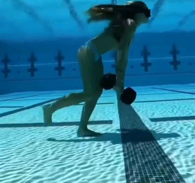 Volleyball player walking with dumbbells underwater