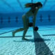 Volleyball player walking with dumbbells underwater