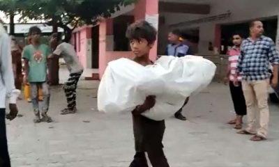 boy carries baby brother's body in his arms