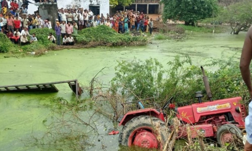 tractor-trolley falls into pond