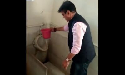 Education Minister Praful Panseria cleans school's dirty toilet