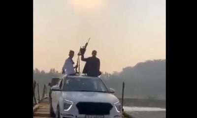 men flaunting weapon in moving car
