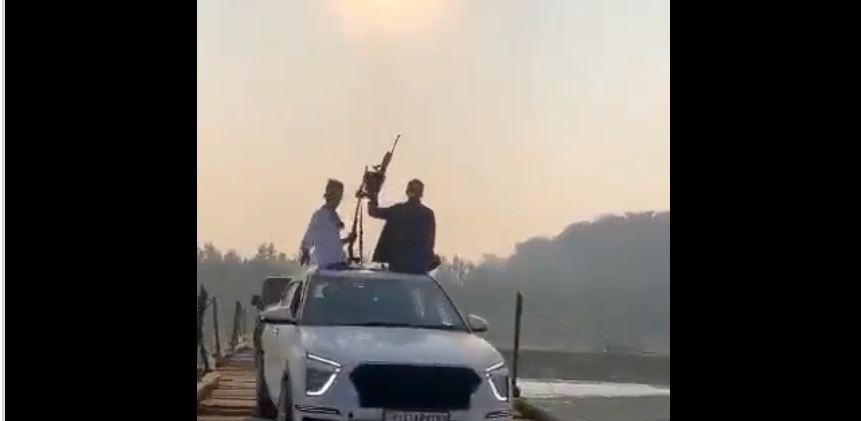 men flaunting weapon in moving car