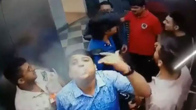 men drinking, smoking inside lift